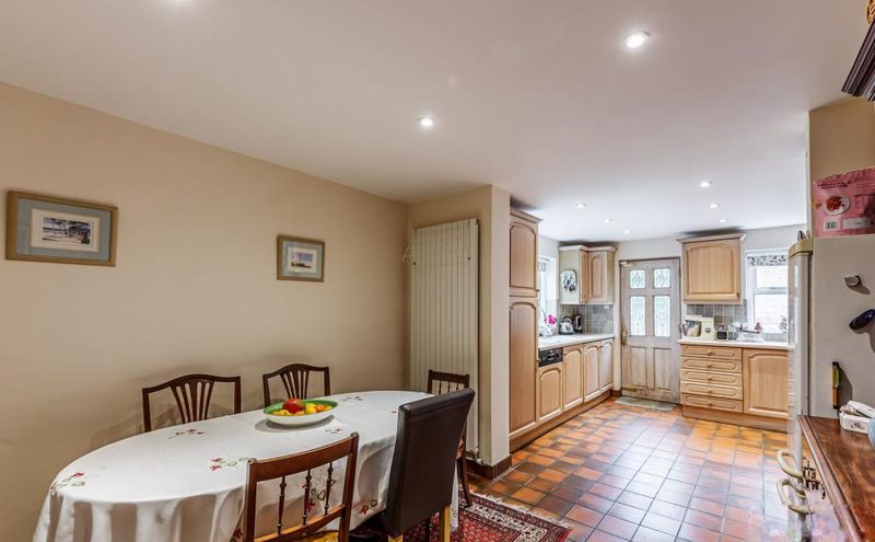 A dining table and chairs at one end of the kitchen, looking through to the units.